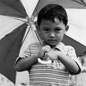 Boy holding striped umbrella