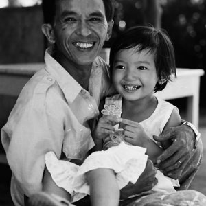 Smiling father holding smiling daughter