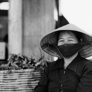 Woman wearing conical hat and black mask