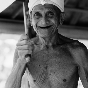 Smiling old man holding knife