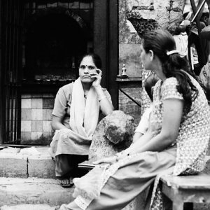 Women sitting in front of small Hindu shrine