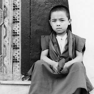 Little Buddhist monk sitting on steps