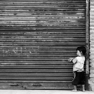 Boy playing in front of shutter