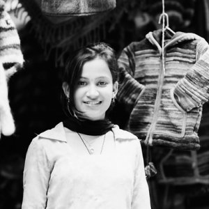 Young woman standing in front of sweaters
