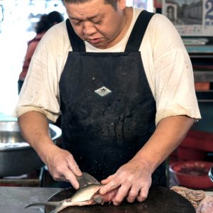 Fishmonger cutting fish