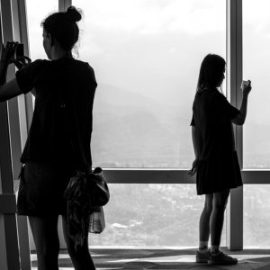 Two silhouetted women taking photos