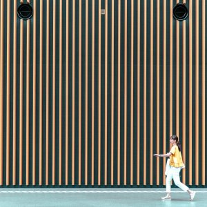 Woman in front of tall wall