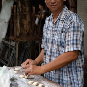Man cutting stretched dough