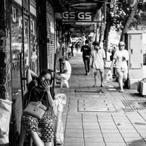 Woman leaning back on sidewalk