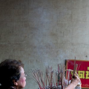 Woman offering incense sticks