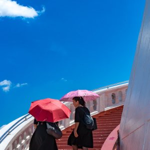 Women climbing red stairway in Wat Saket