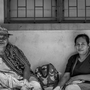 Women sitting against wall