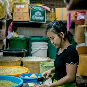 クーロントゥーイ市場で野菜をカットする若い女性