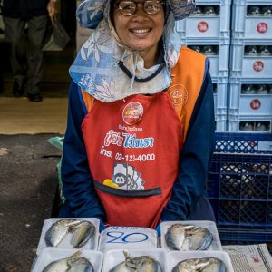 パック詰めの魚を売る女