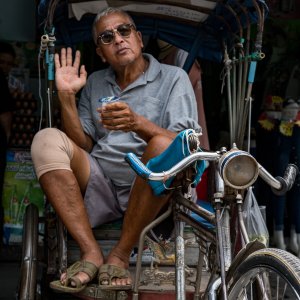 Shade-wearing man sitting on bike taxi