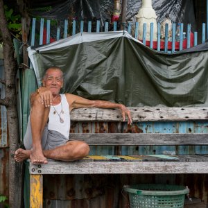 Old man sitting on wooden bench