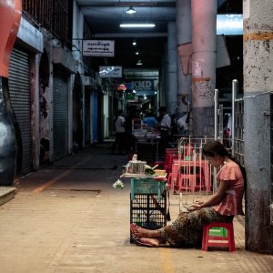 Young woman selling Kun in deserted passage