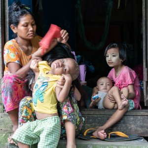 Mother and kids relaxing at the entrance of house