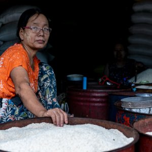 米でいっぱいになった容器と女性