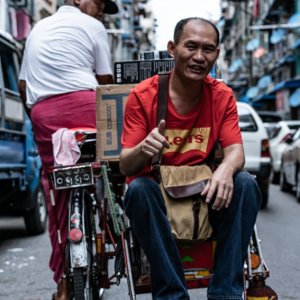 Man thumbing up on seat of pedicab