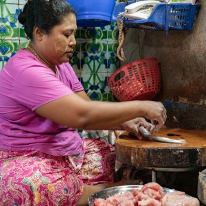 Woman removing scale in market