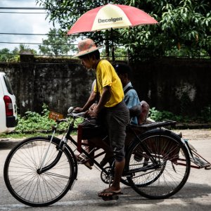 Pedicab with umbrella passing by