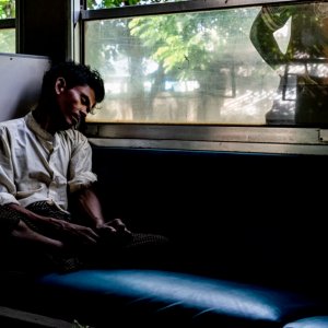 列車の車内で熟睡する男