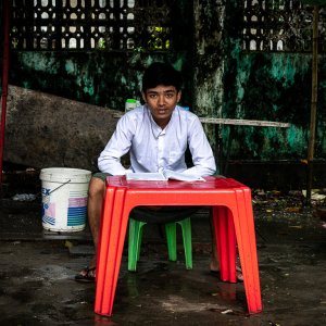 Schoolboy studying at red table
