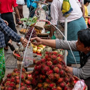 Man selling rambutan and sugar apples
