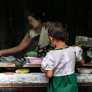Little girl buying in delicatessen