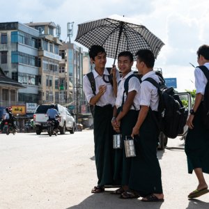 Schoolboys waiting for bus by roadside