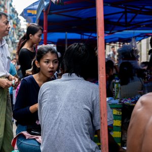 Young woman having meal in food stall