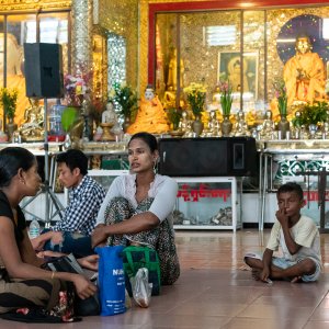 Local people relaxing in front of Buddha statues
