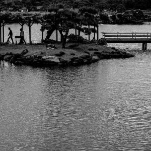 潮入の池に浮かぶ小島の上を歩くシルエット