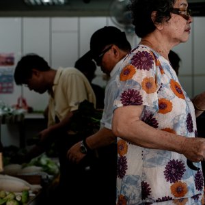 堂々とした雰囲気で野菜売り場を通り過ぎる年配の女性