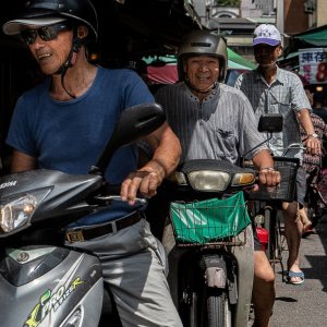 白蘭市場を走る二台のバイクと一台の自転車