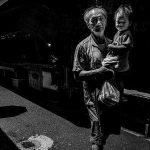 Little kid held by grandfather in Bailan Market