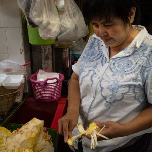 Woman peeling a big fruit