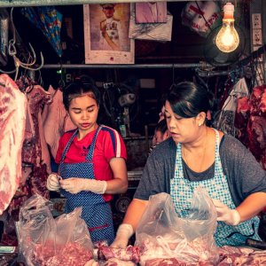 Two woman working together in a butcher in Khlong Toei Market
