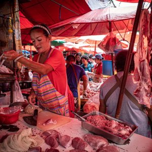 Woman cutting pork in Khlong Toei Market