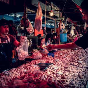Man buying meat in a butcher in Khlong Toei Market
