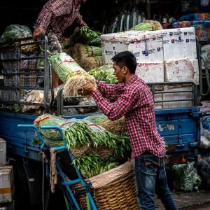 クロントゥーイ市場でトラックから野菜を下ろしていたふたりの男