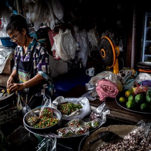 woman cutting bamboo sprouts in Maeklong Railway Market