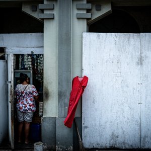 ジャカルタの町角の壁にかかる赤いワンピース
