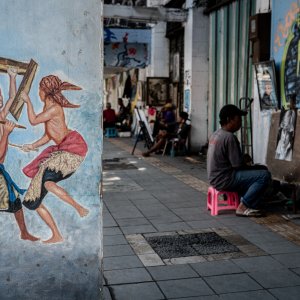 Painters on the sidewalk and the picture depicted on the pillar