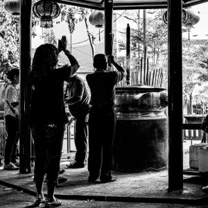 ジャカルタにある金徳院の香炉の回りでお祈りしていた人びとのシルエット