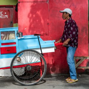 Jakarta peddler pushing a bright stall
