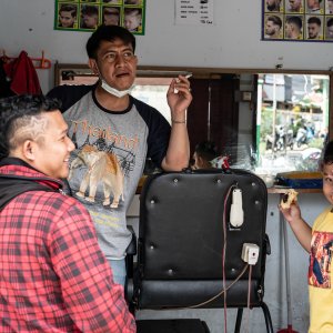 Three persons hanging out in a barbershop