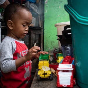 Little boy playing with working car toys