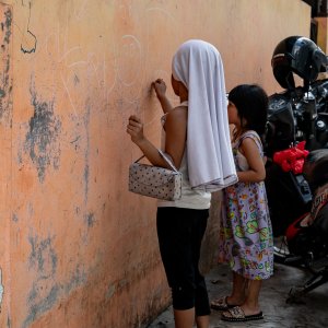 Girls scribbling on the wall